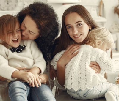 A joyful family gathering in a cozy kitchen with three generations bonded in happiness.